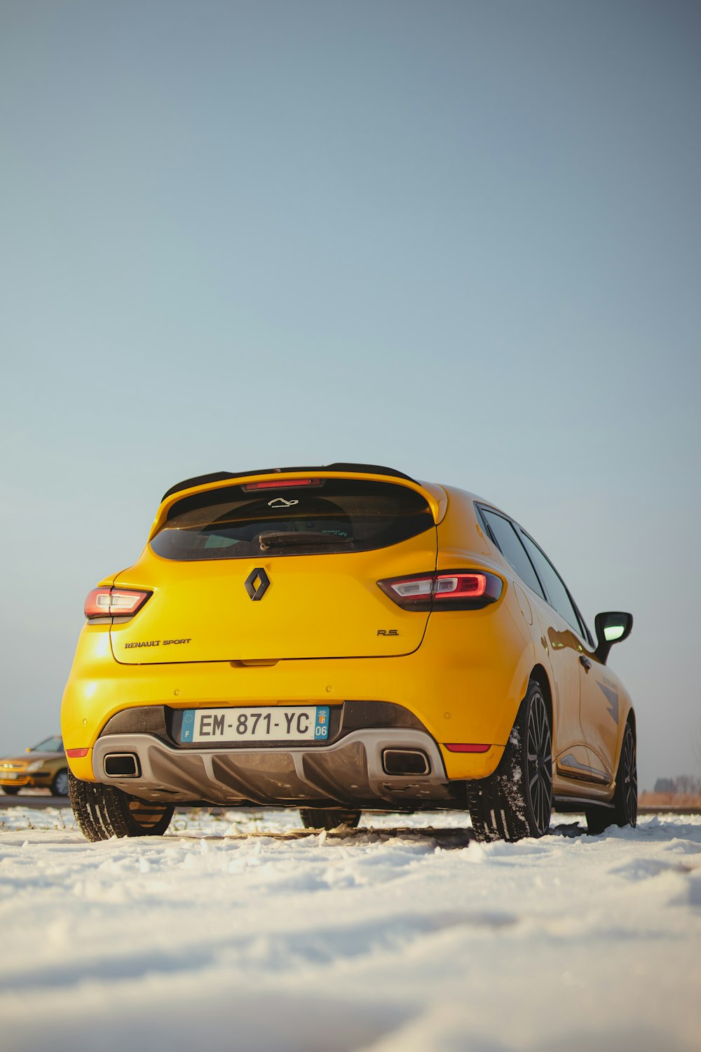 a yellow car is parked in the snow