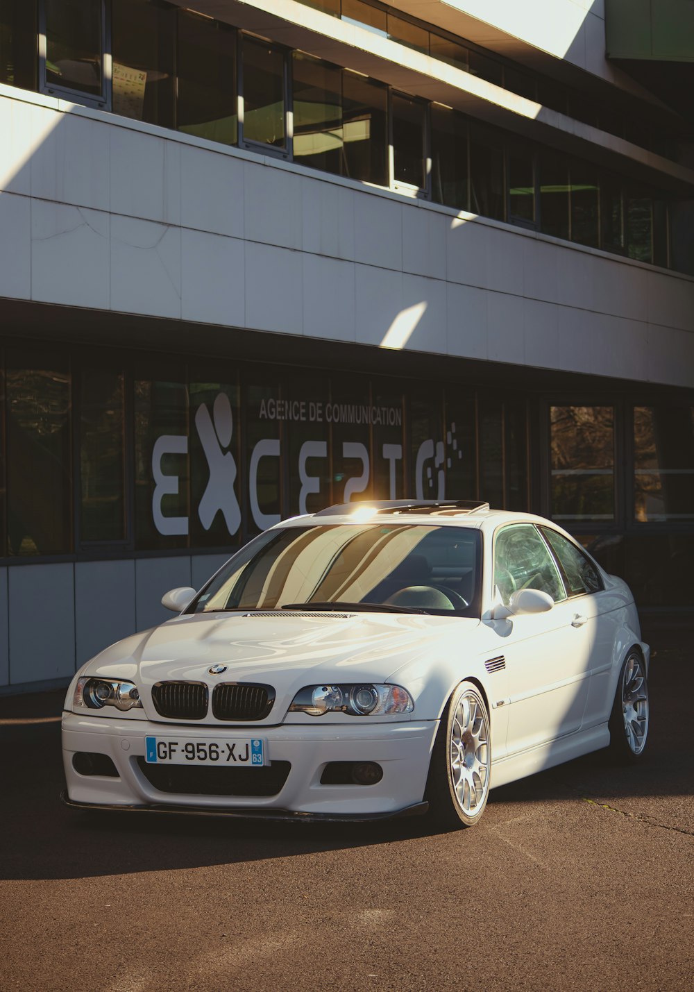 a white car parked in front of a building