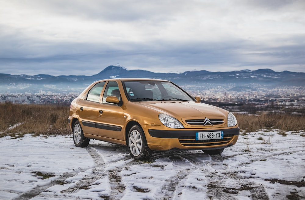 um carro de ouro estacionado em uma estrada nevada