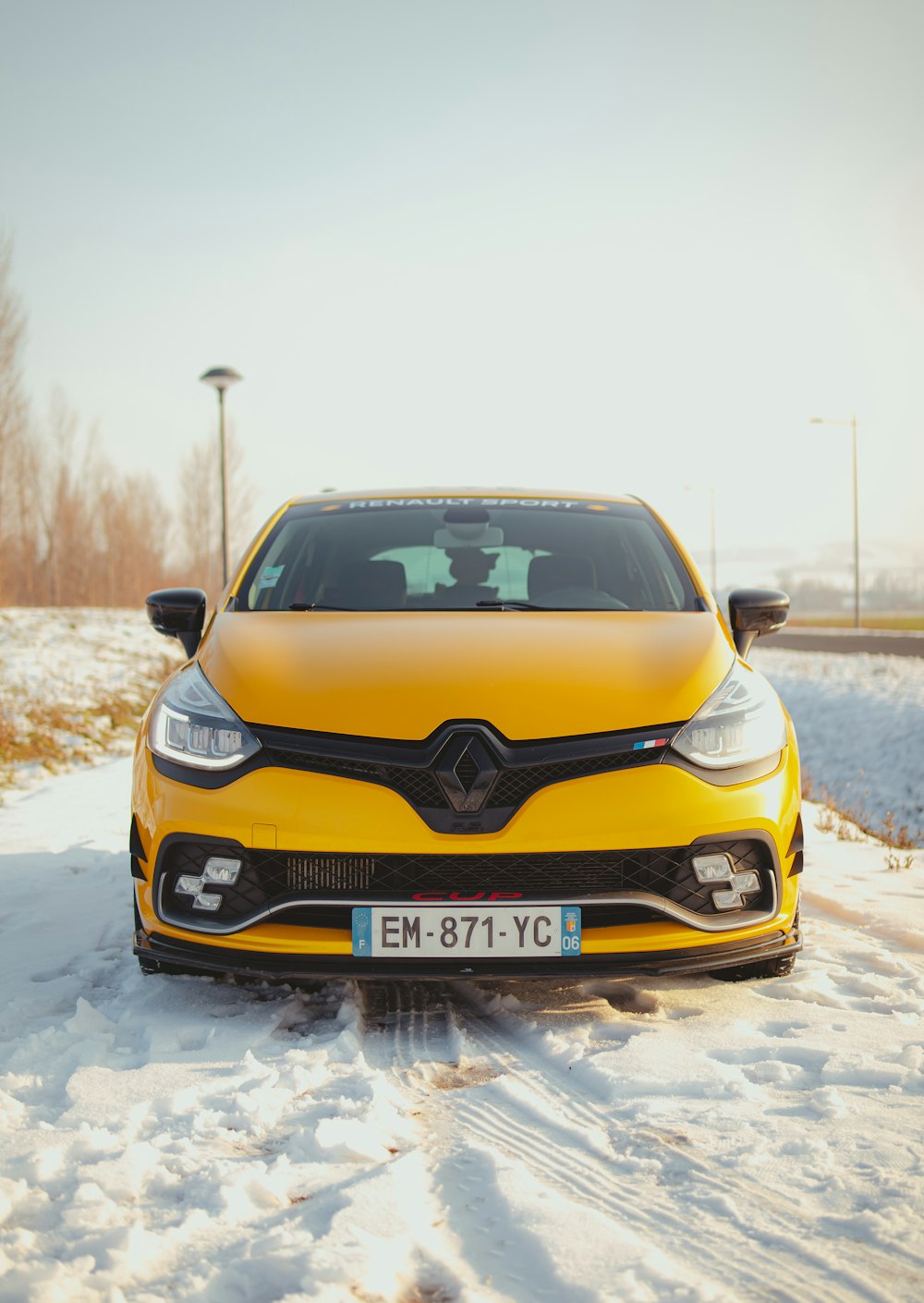 a yellow car is parked in the snow