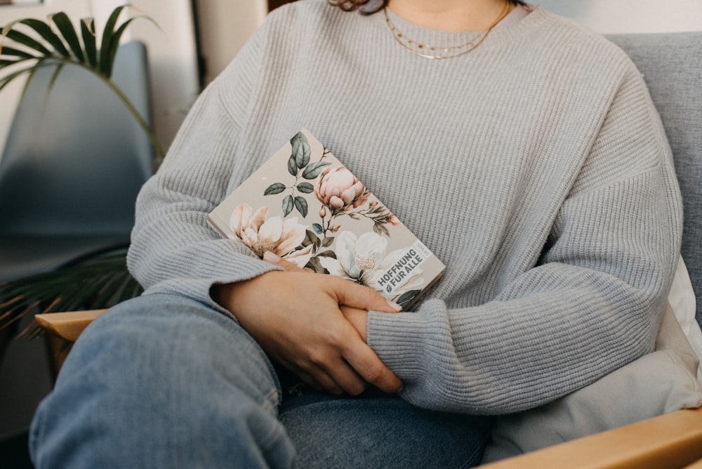 a woman sitting in a chair holding a book