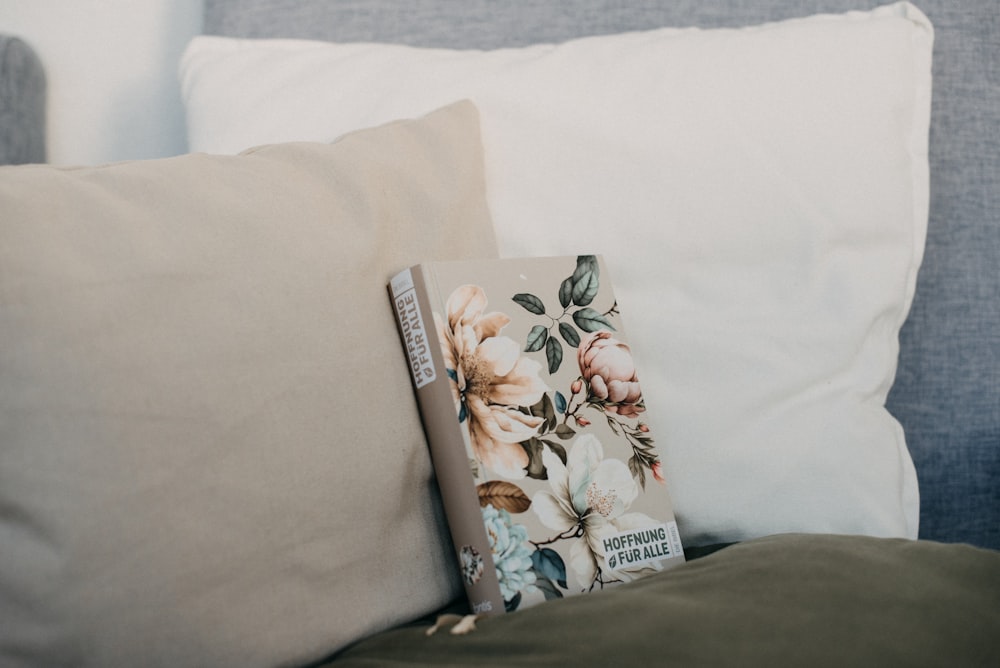 a book sitting on top of a pillow on a bed