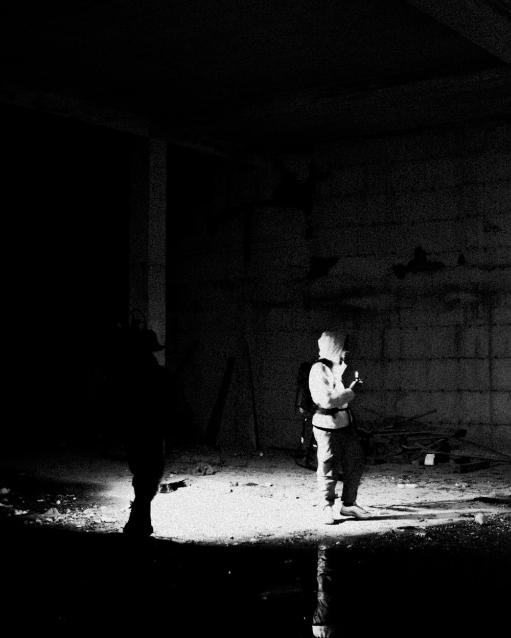 a black and white photo of a person standing in a dark room