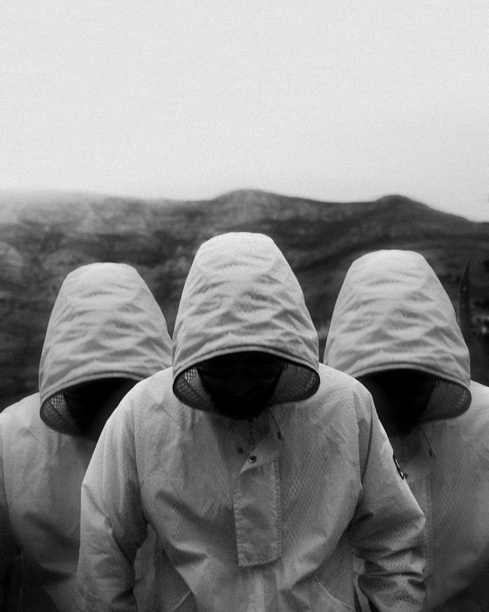 a group of people in raincoats walking in the rain