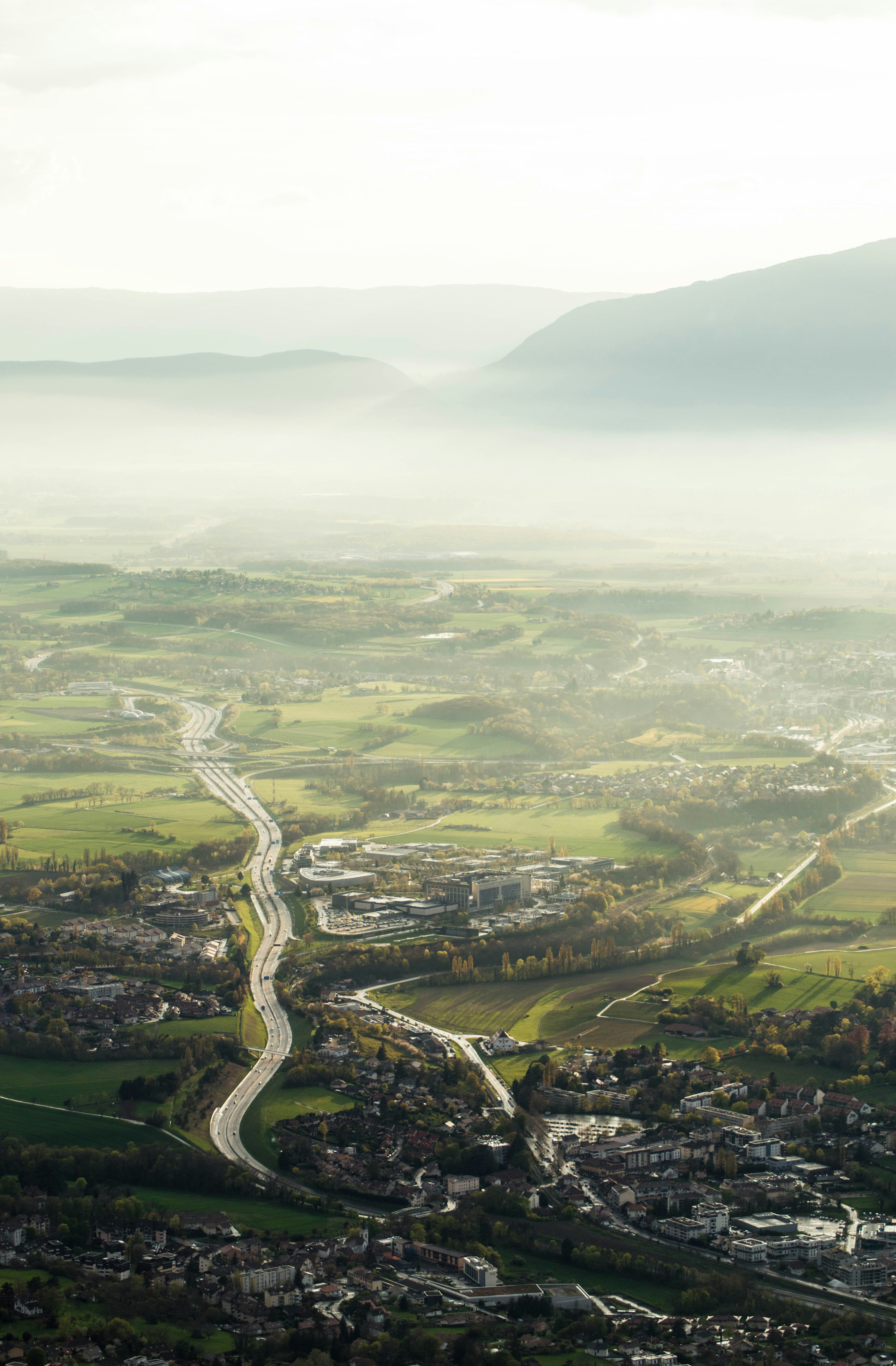 An aerial view of a city and a winding road photo – Free Mountains ...