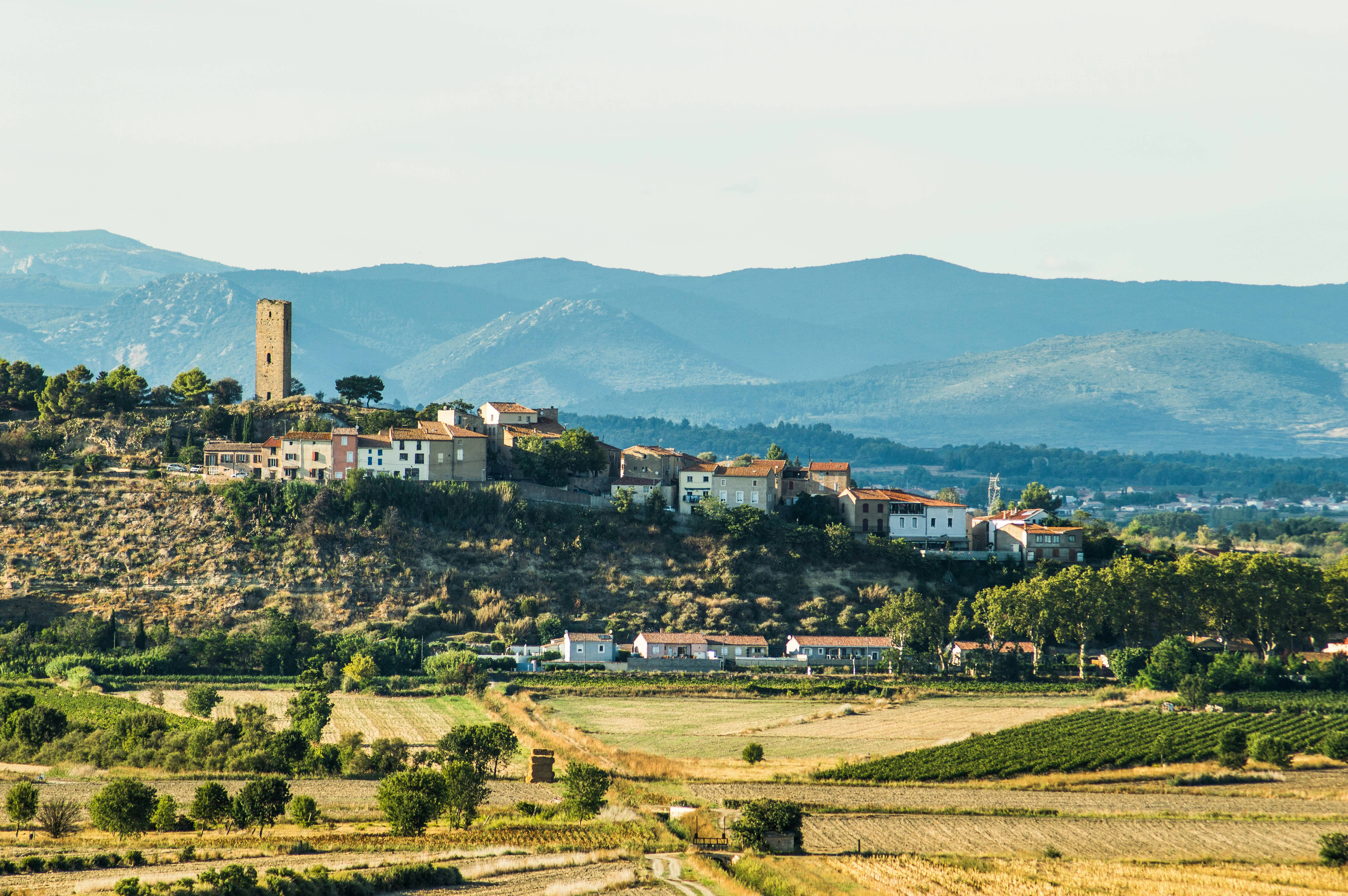 a village on a hill with mountains in the background