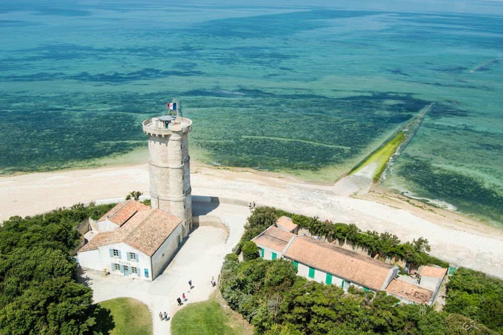 an aerial view of a lighthouse on a beach