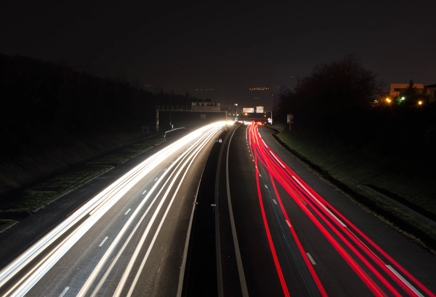 Light trails above a highway at night