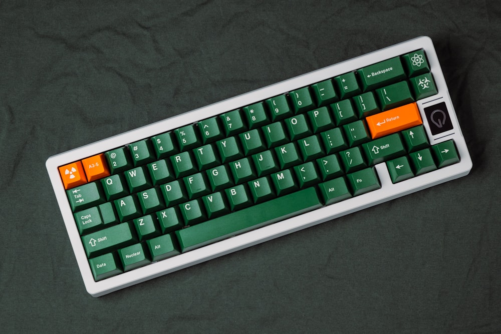 a green and orange keyboard on a black surface