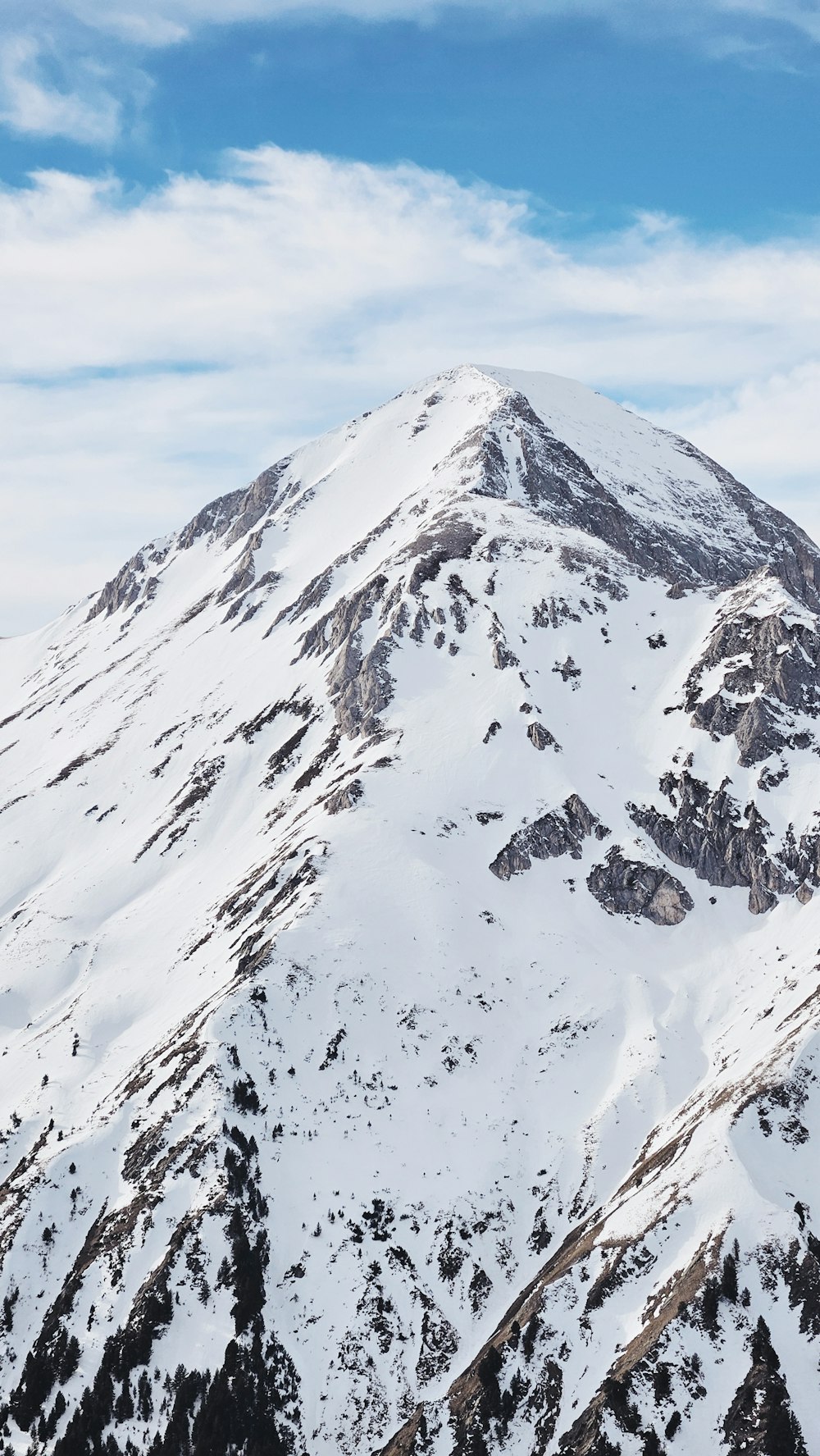 a mountain covered in snow under a blue sky