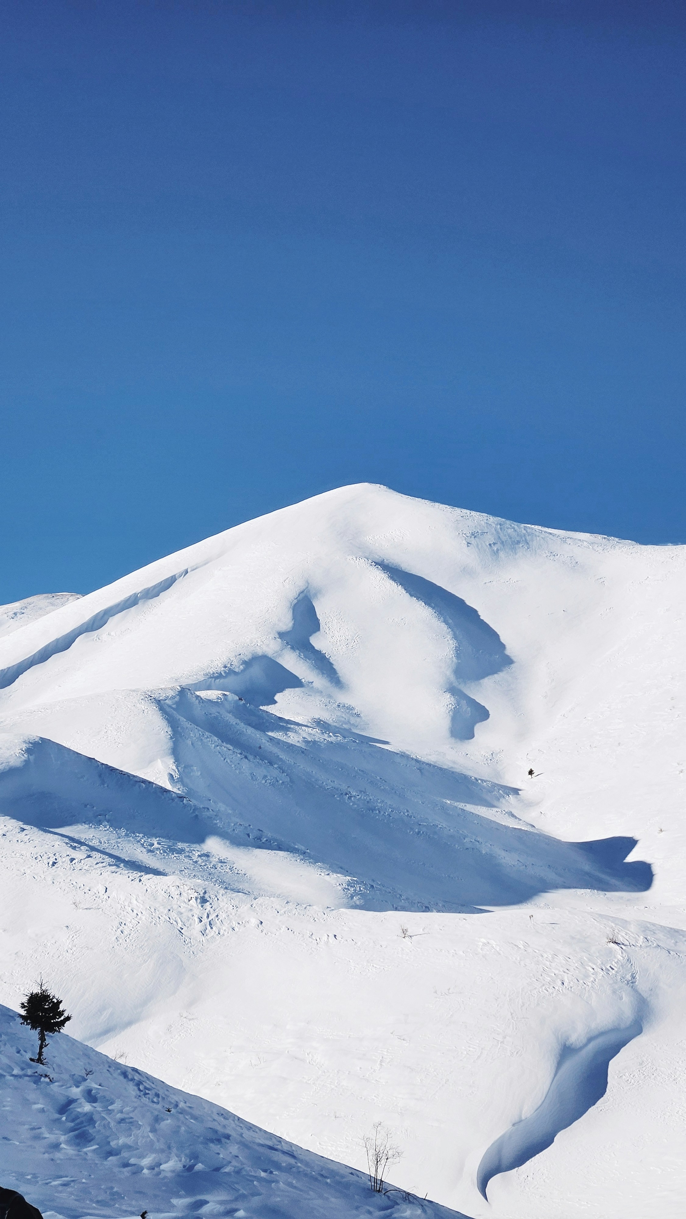 ein schneebedeckter Berg unter blauem Himmel