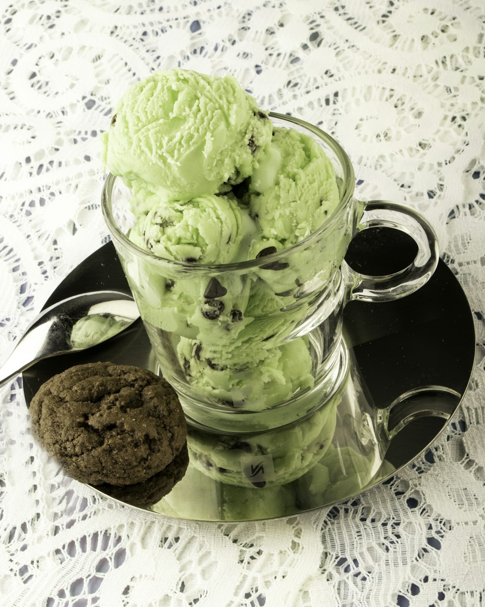 a glass cup filled with ice cream next to a cookie