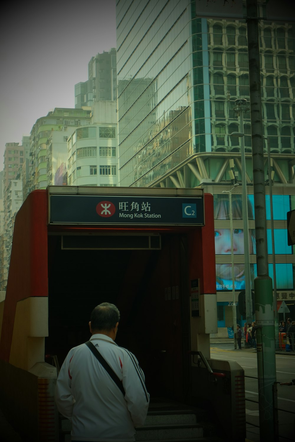 a man standing at a bus stop in a city