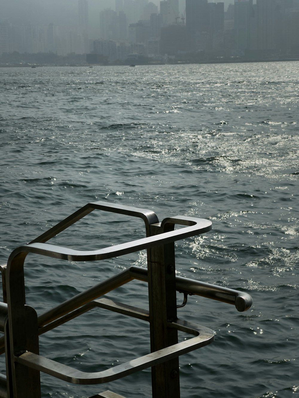 a metal railing in the middle of a body of water