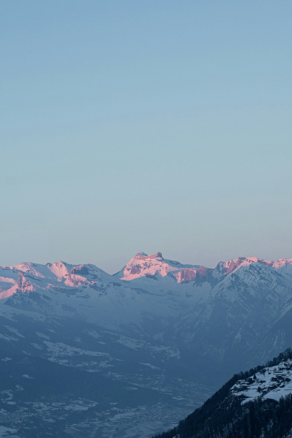 uma vista de uma cordilheira com neve sobre ela