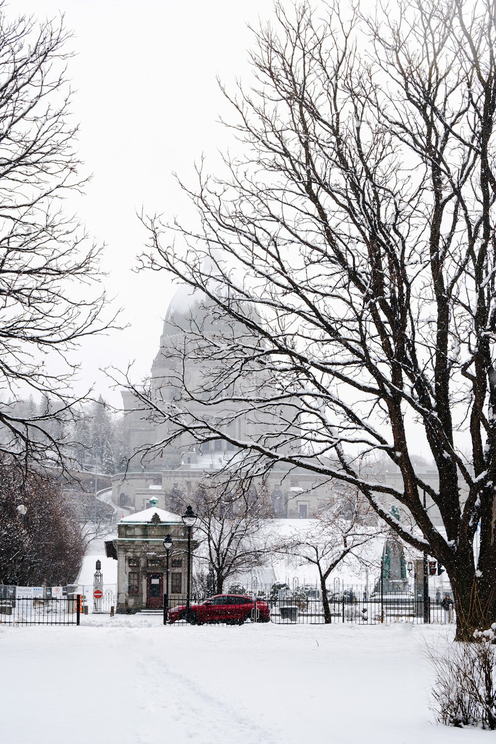 a snow covered park with a clock tower in the background