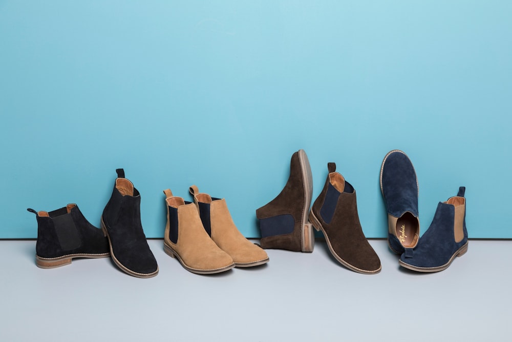 a row of different colored shoes lined up against a blue wall