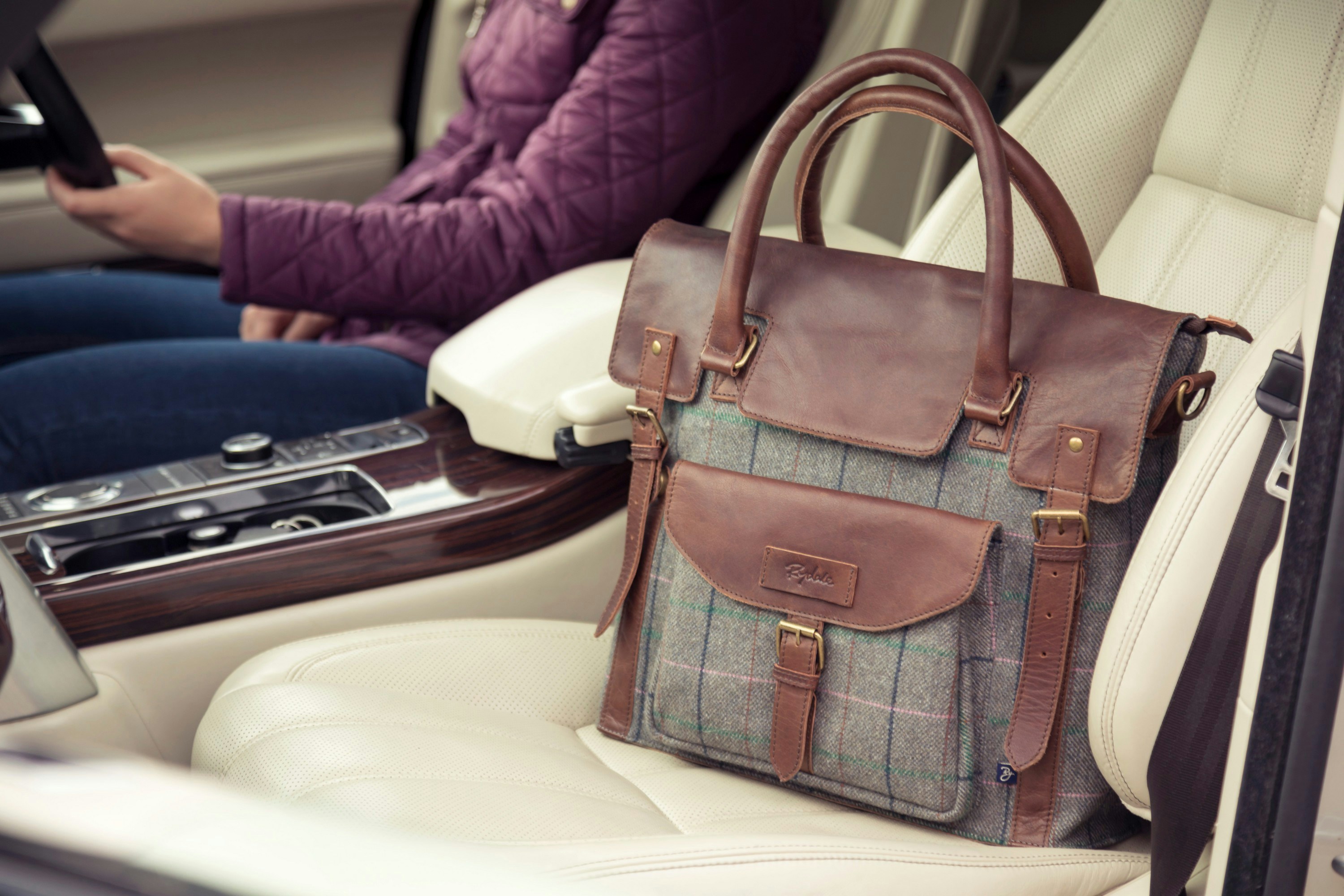 a woman sitting in a car holding a cell phone