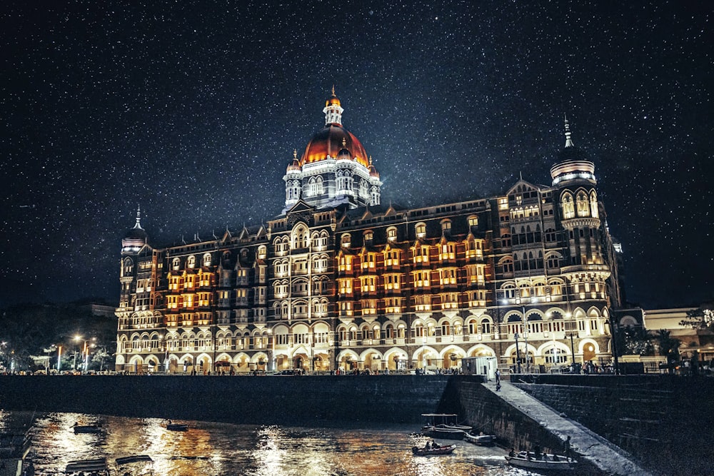 a large building lit up at night on the water