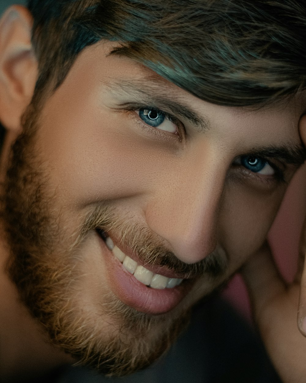 a close up of a person with a beard and blue eyes