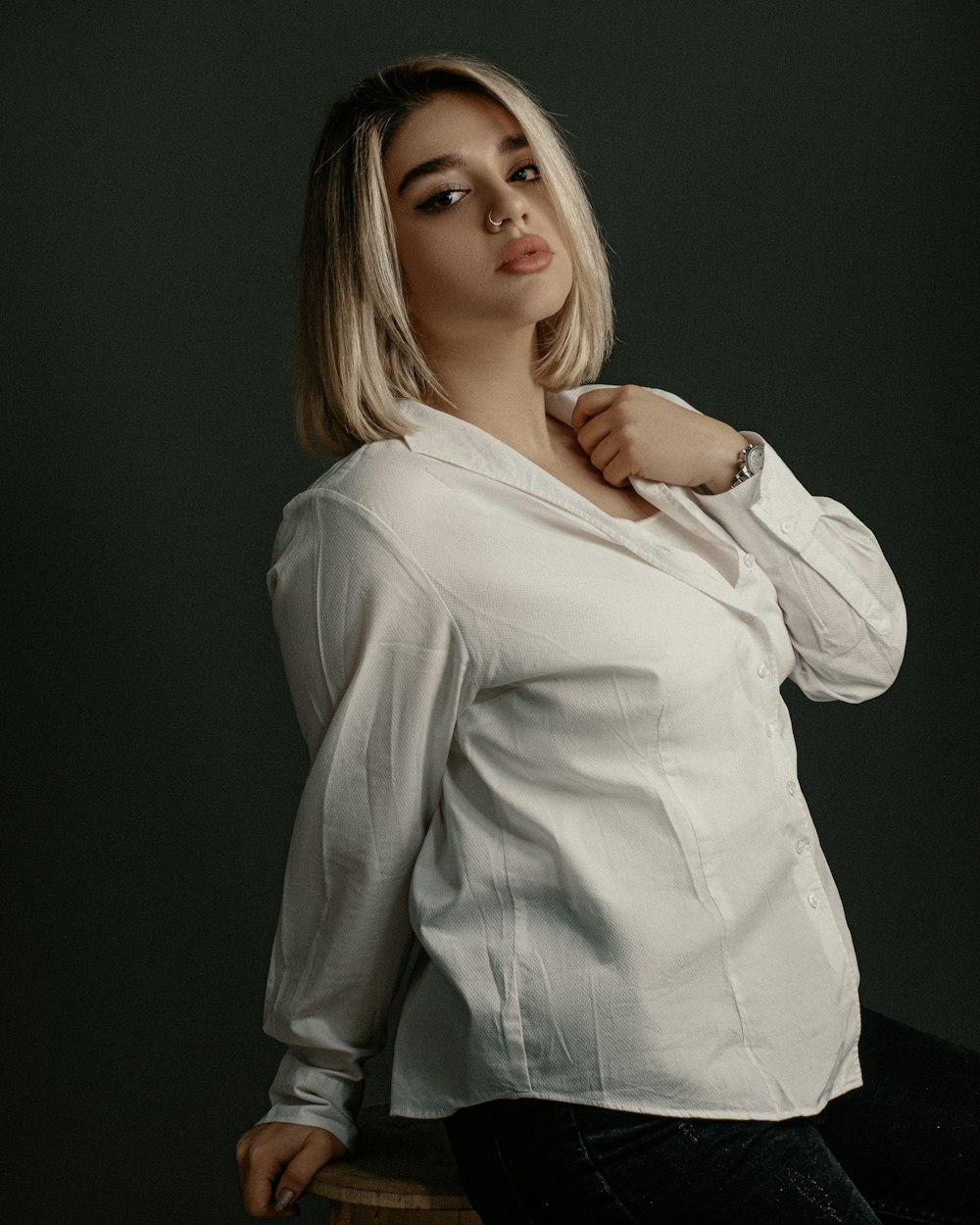 a woman sitting on a stool posing for a picture