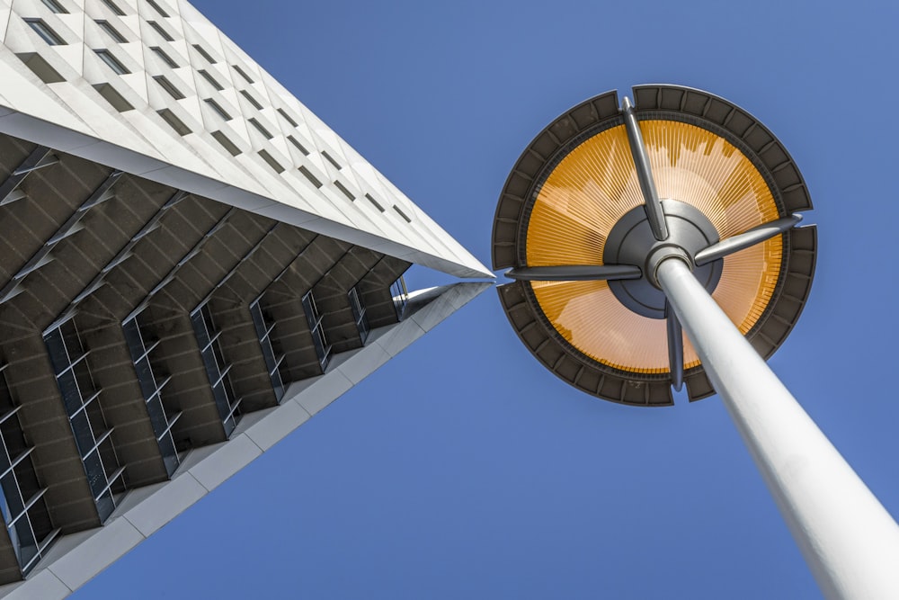 a tall white pole next to a tall building