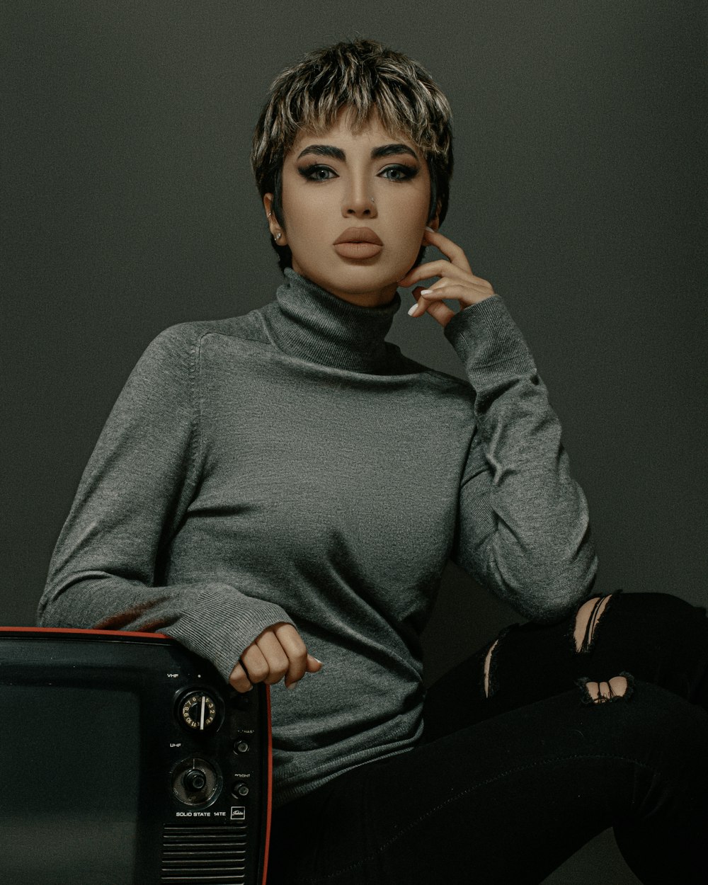 a woman sitting on top of a tv