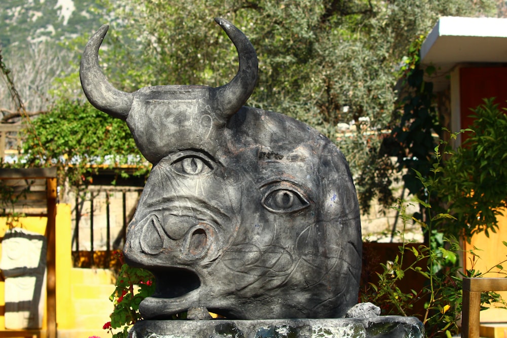 a statue of a rhino head in front of a house