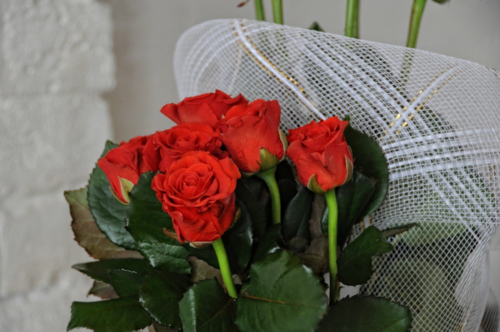 a bouquet of red roses sitting on top of a table