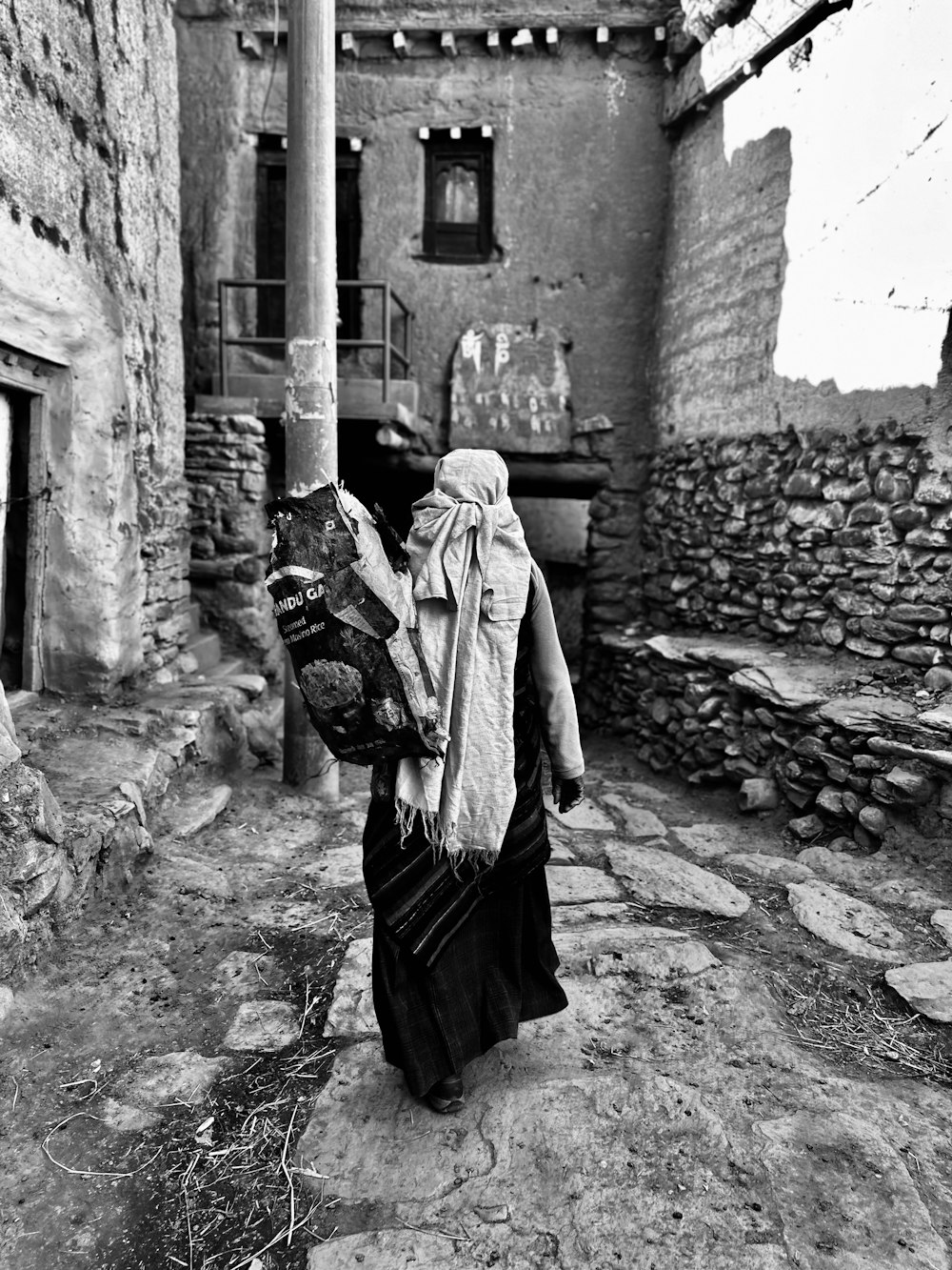Una foto en blanco y negro de una mujer caminando por una calle