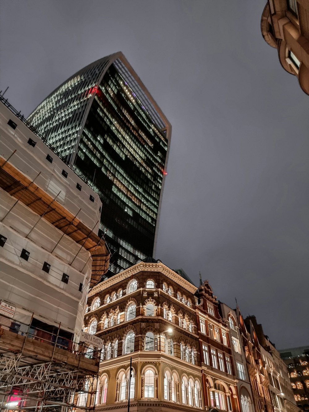 a tall building sitting next to a tall glass building