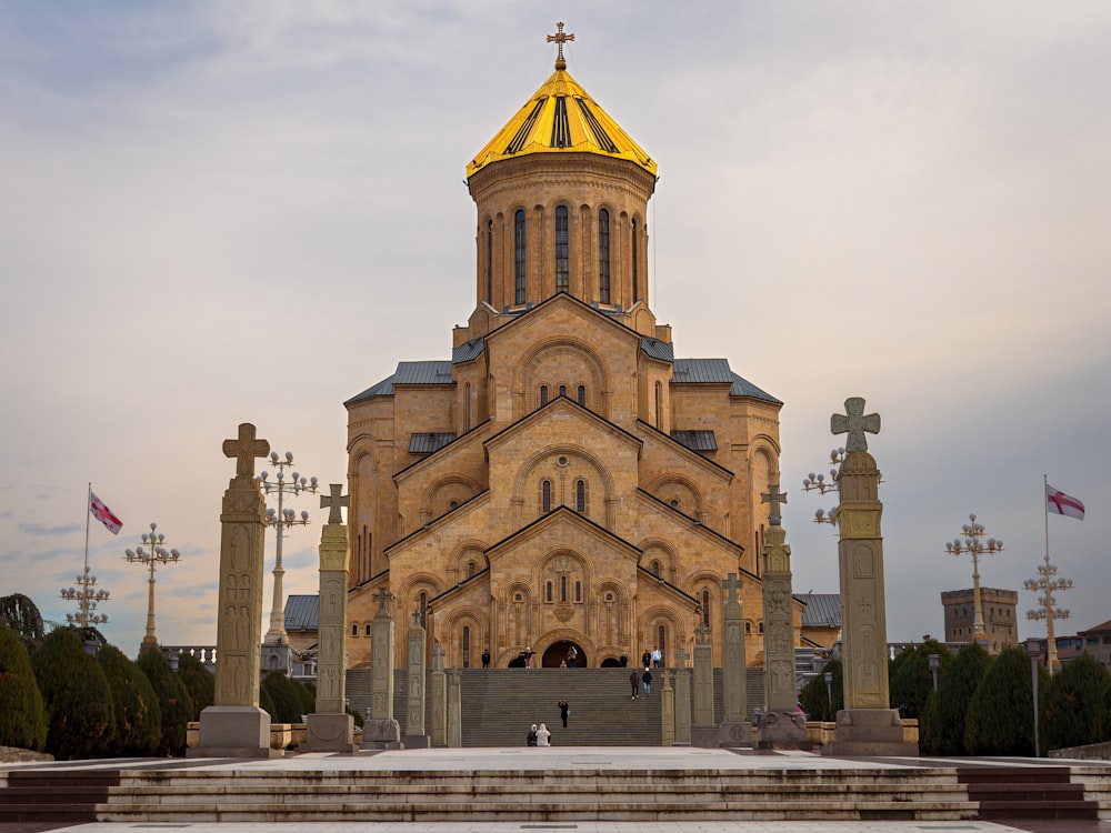 a large church with a golden dome and cross statues
