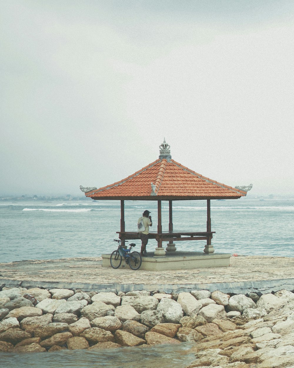 a man sitting on a bench next to the ocean