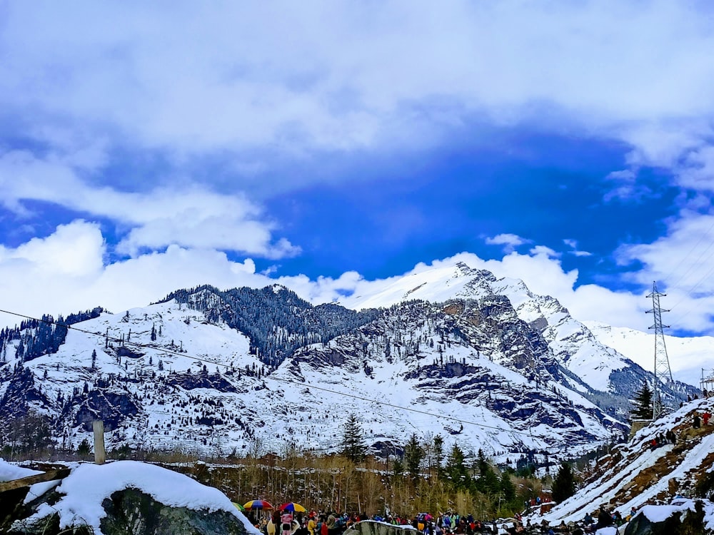 a group of people standing on top of a snow covered mountain