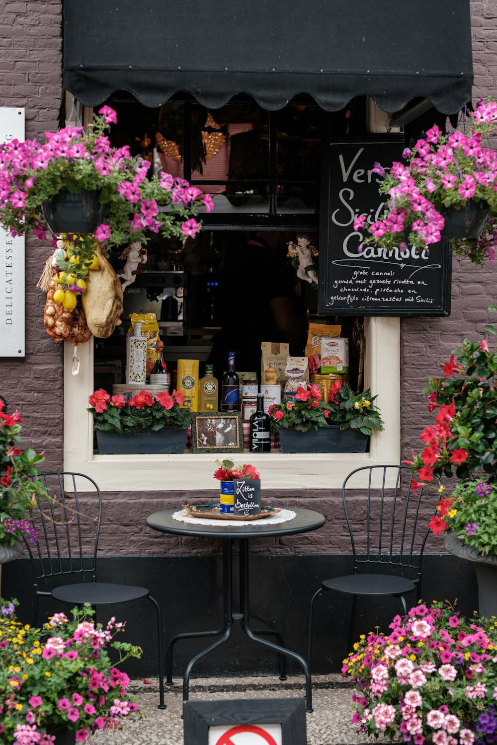 a table and chairs outside of a flower shop