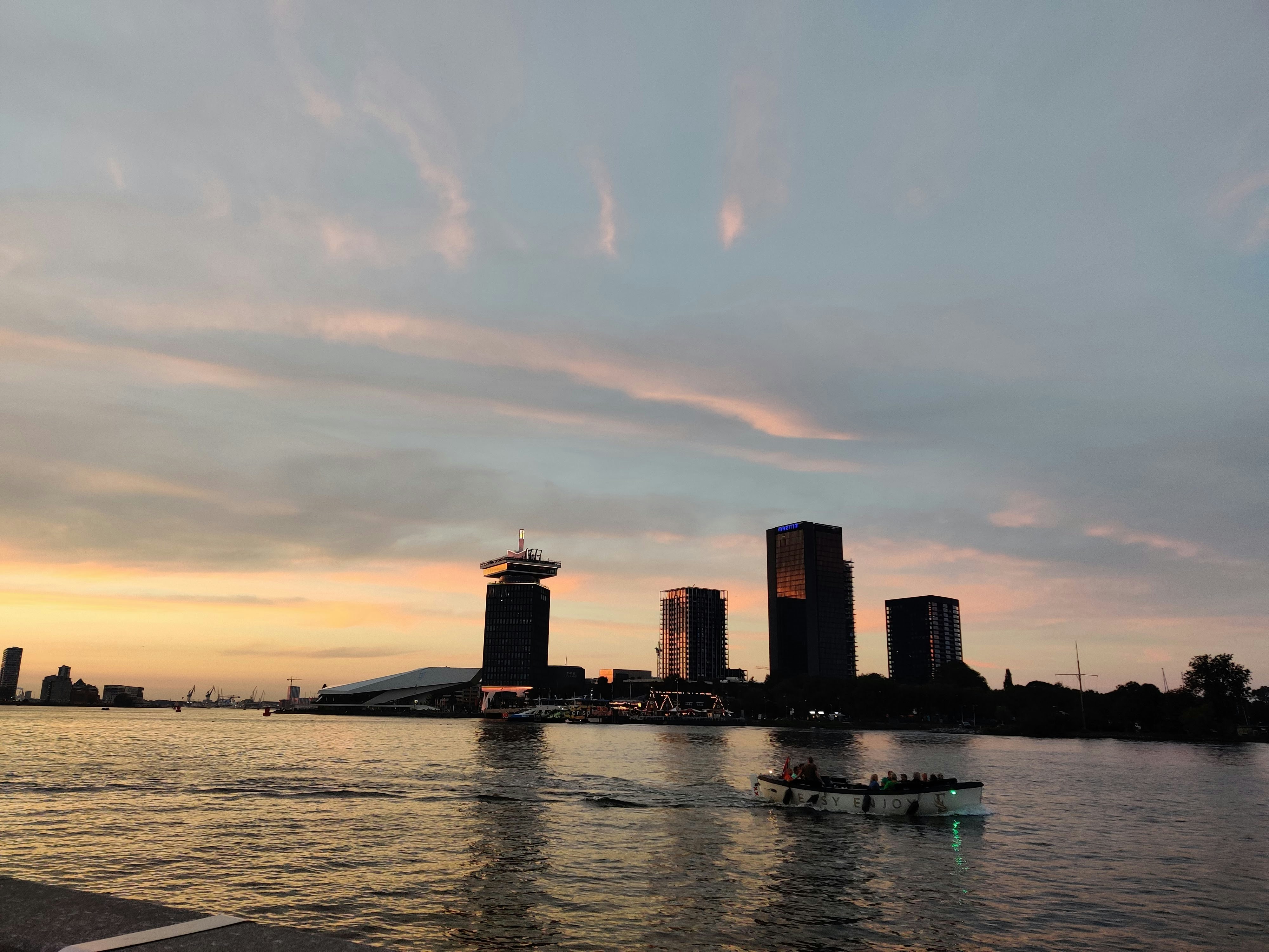 a boat traveling down a river next to tall buildings