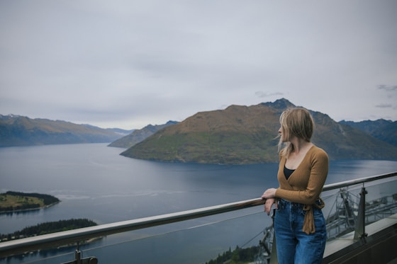 a woman standing on a balcony overlooking a body of water