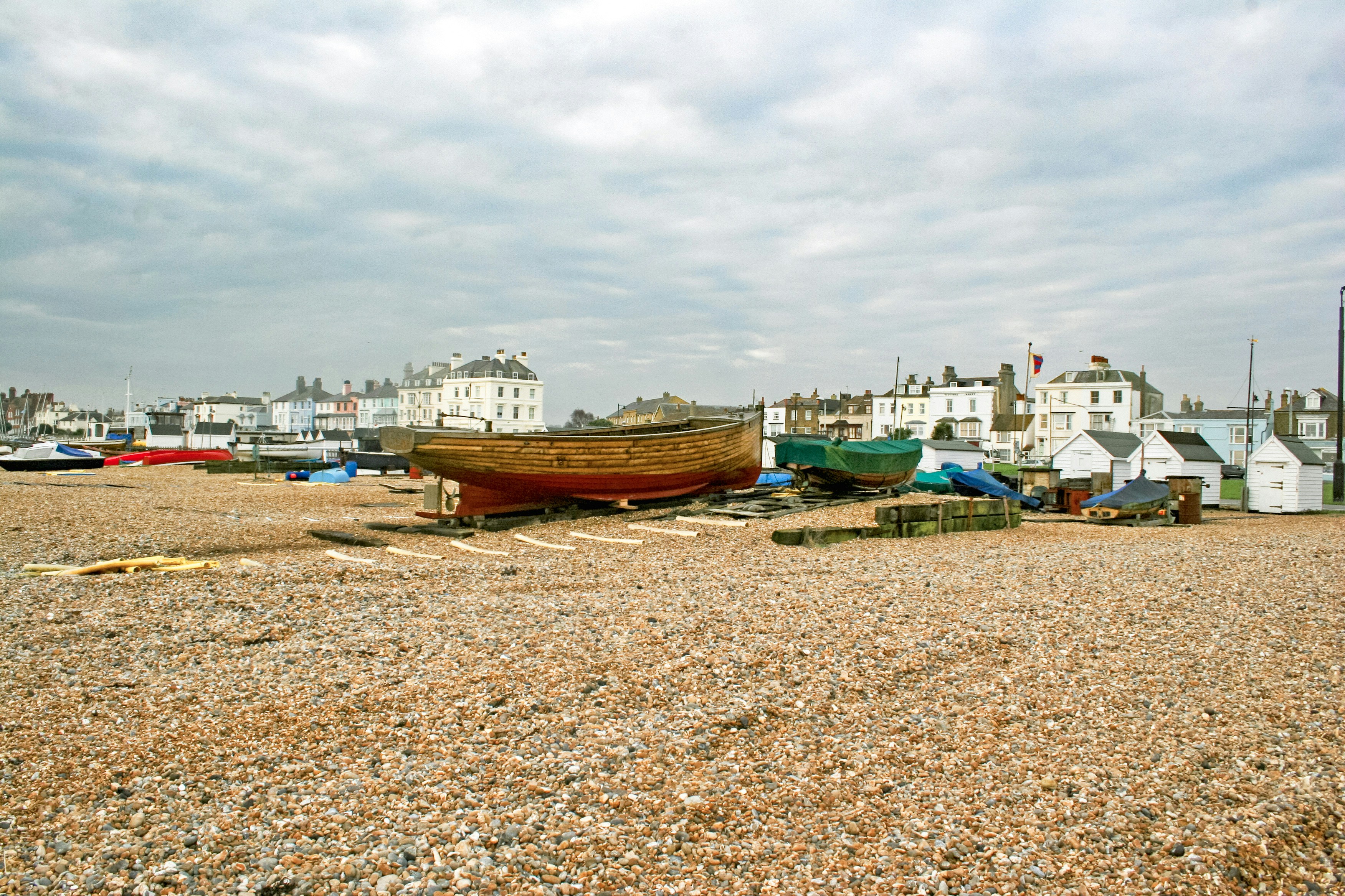 a row of boats sitting on top of a sandy beach