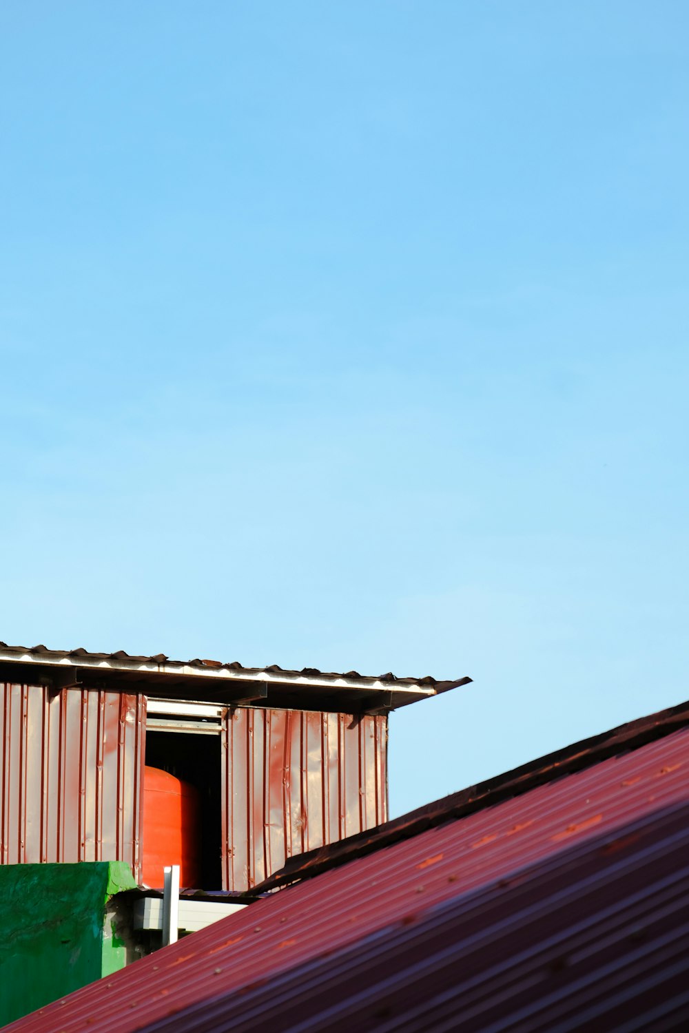 a red and green building with a red roof