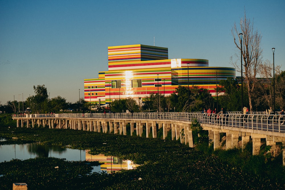 Um grande edifício multicolorido fica ao lado de uma ponte