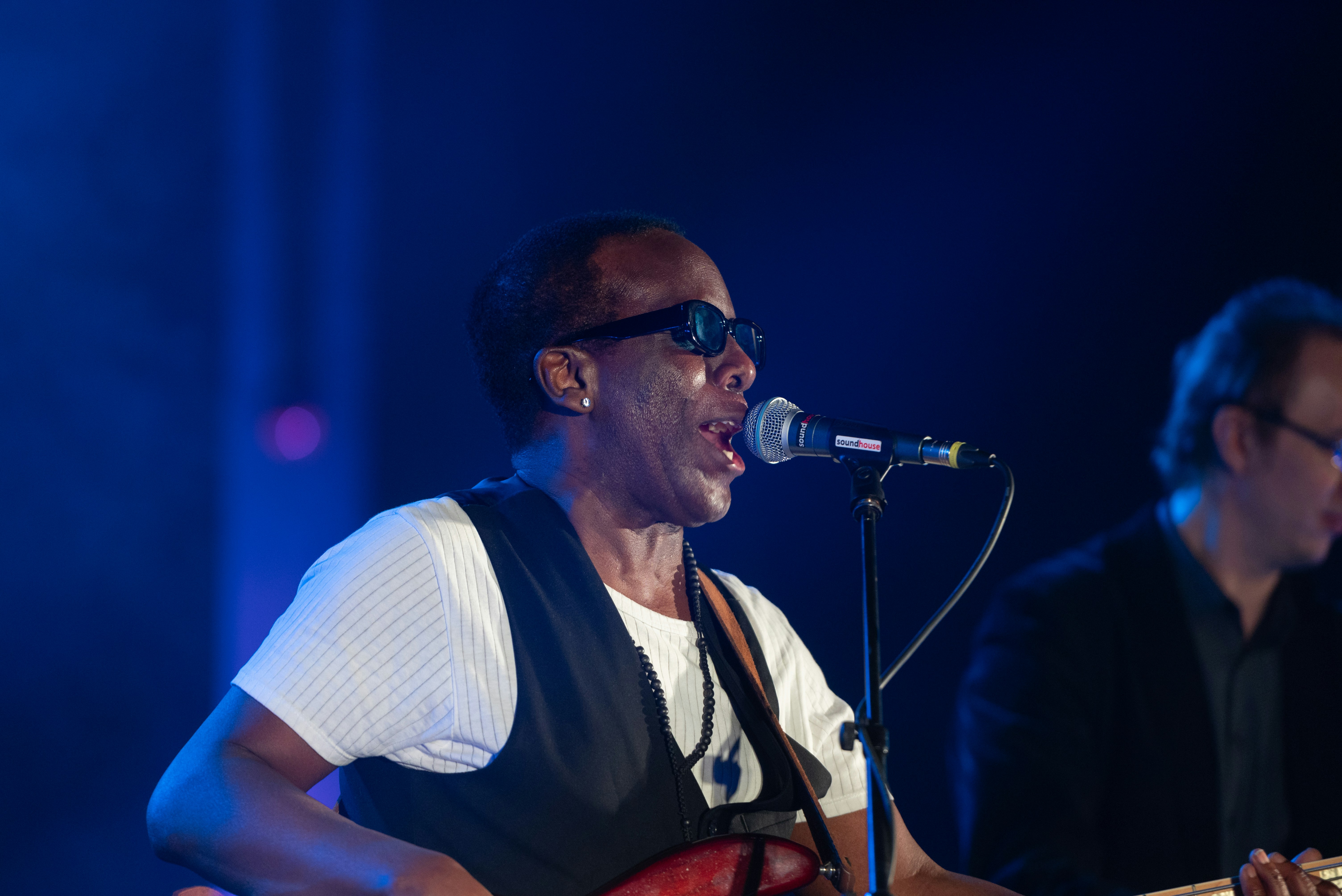 a man playing a guitar and singing into a microphone