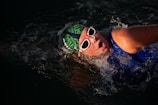 a man swimming in the water wearing sunglasses