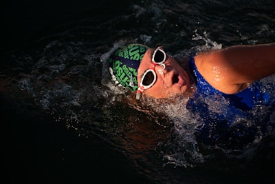 a man swimming in the water wearing sunglasses