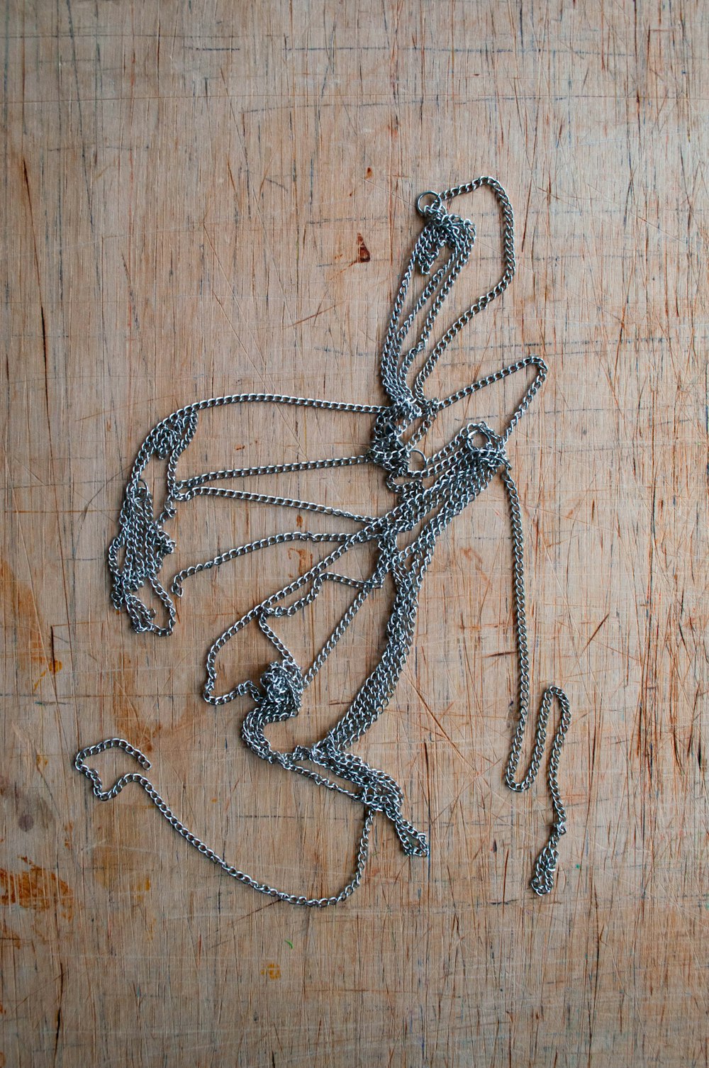 a piece of metal chain sitting on top of a wooden table