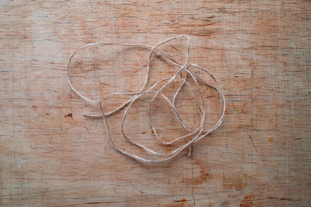 a close up of a string on a wooden surface