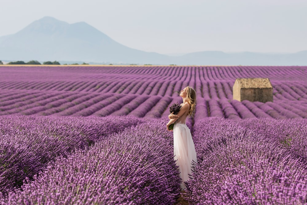 a woman standing in a field of lavender