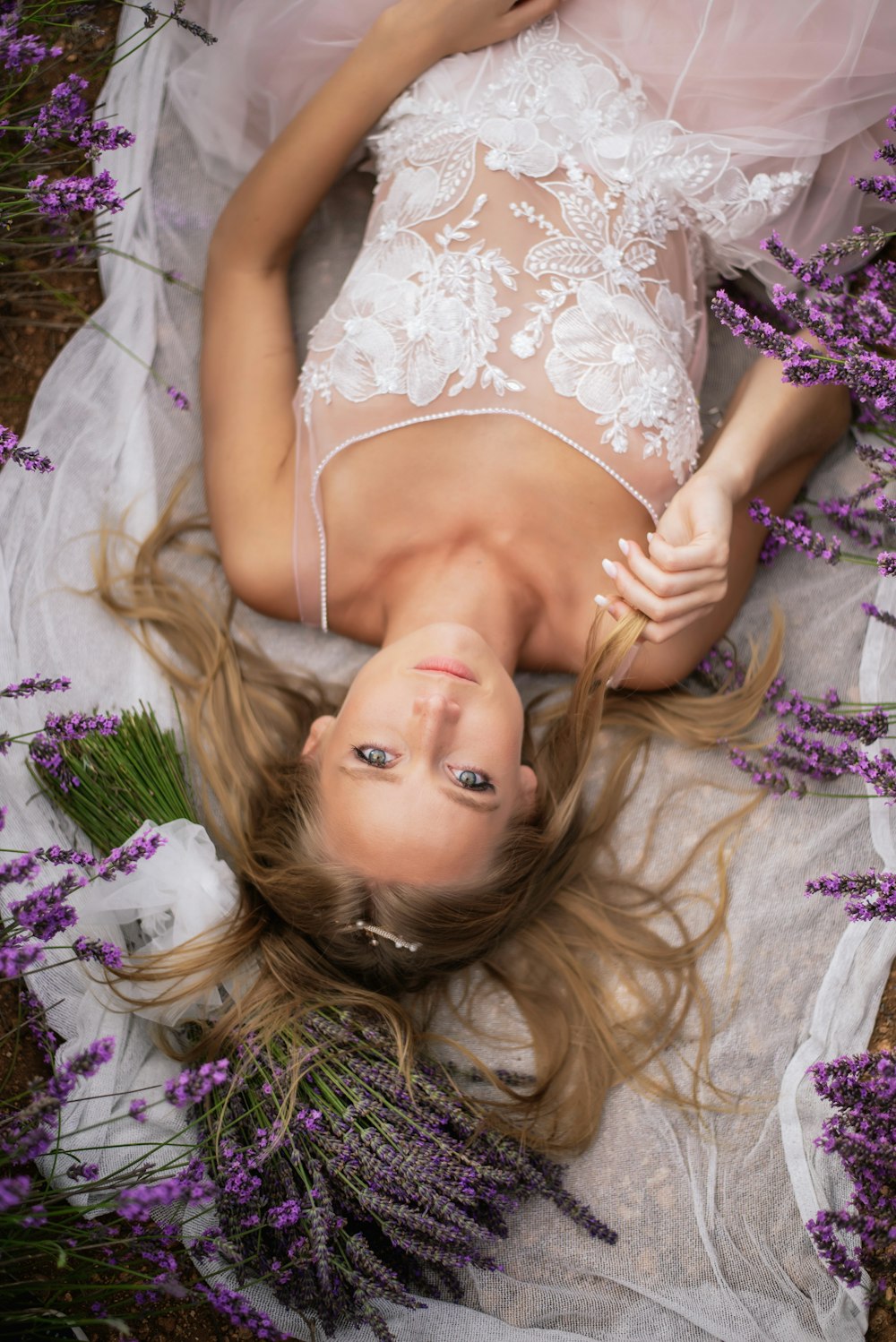 a woman laying on a bed of lavender flowers