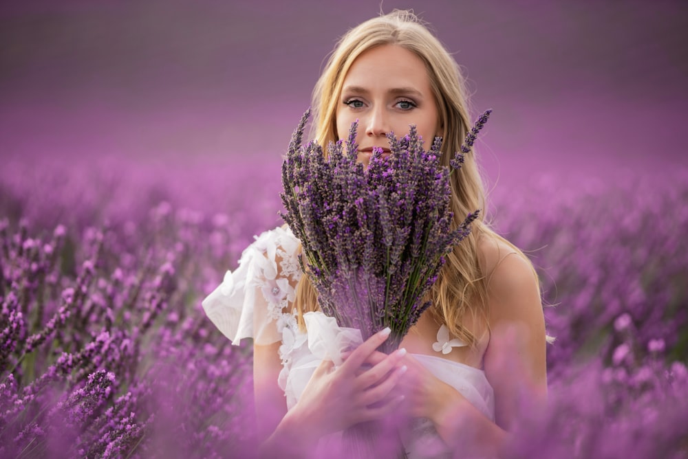 a woman holding a bunch of lavender flowers