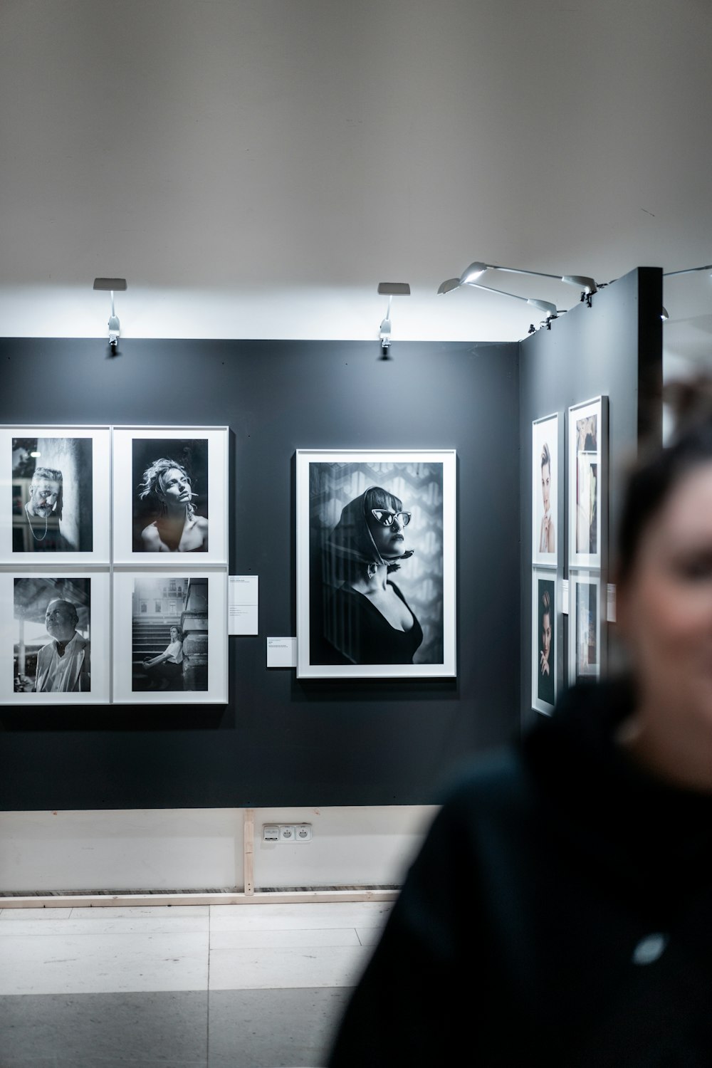 a woman standing in front of a wall with pictures on it