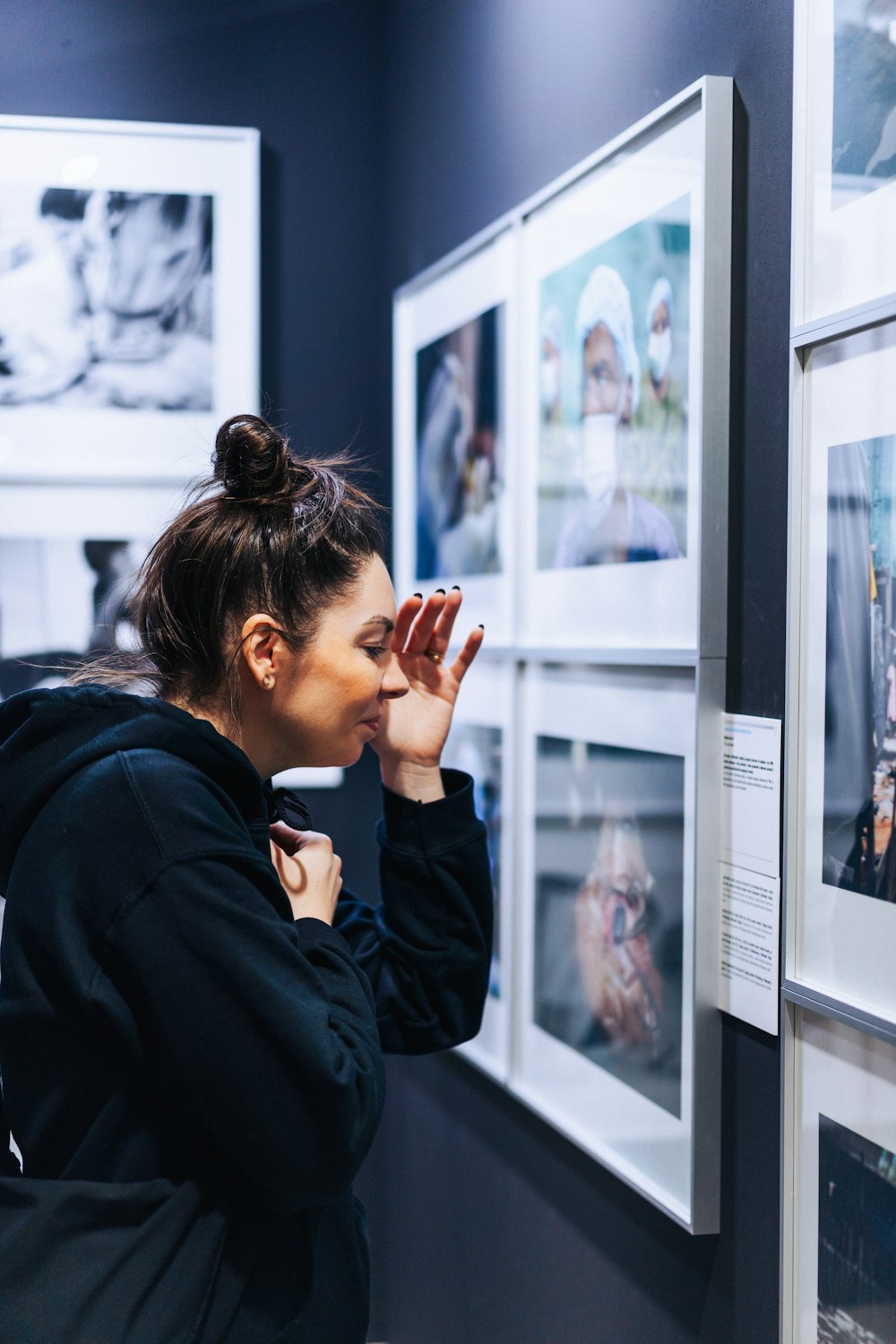 a woman looking at pictures on a wall